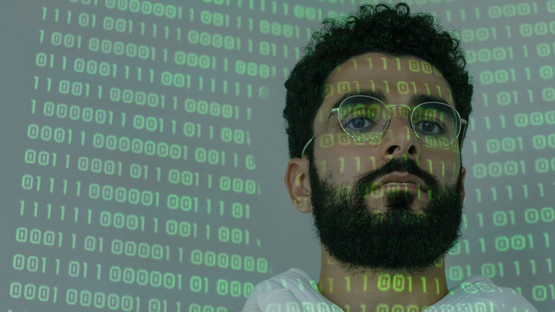 Códigos de linguagem científica são refletidos em rosto de cientista