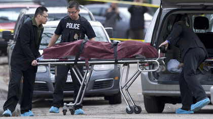 Police remove a body from the scene of a multiple fatal stabbing in northwest Calgary