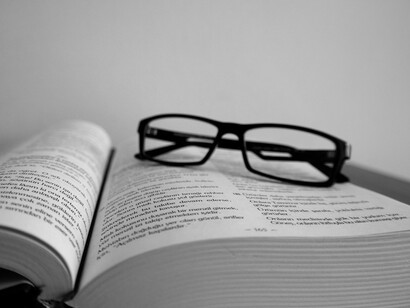 Gafas dejadas sobre un texto académico. El papel crucial de la filosofía en la comprensión profunda del universo