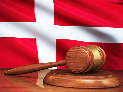 A visual representation emerges as the gavel rests beside the Danish flag, symbolizing the synergy between the nation's constitution and the pursuit of justice