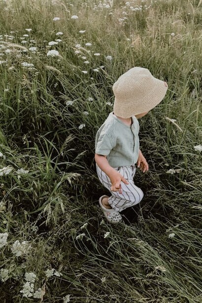 Niño caminando en el pasto florido, foto de Saliha Sevin