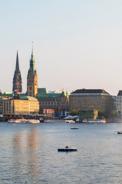 Daytime boaters on the Alster, with Hamburg’s cityscape in the background