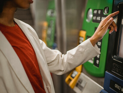 A woman withdraws money from an automated teller machine in an everyday urban setting