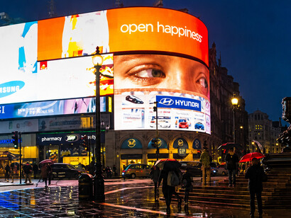 The famous illuminated billboards of Piccadilly Circus light up the crowds surrounding the iconic Eros statue in central London, UK