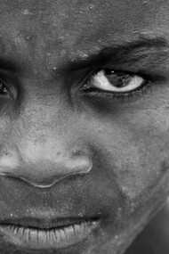 A black child stares defiantly into the camera