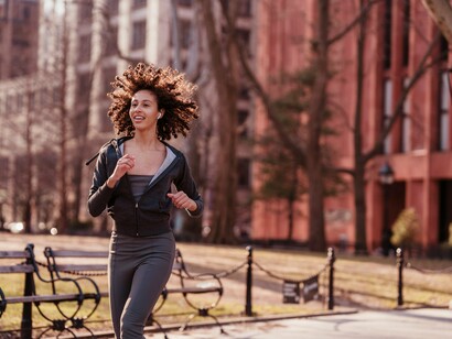 Mulher corre feliz enquanto ouve música. Estudos recentes têm demonstrado que a música pode influenciar diretamente os níveis de cortisol, o hormônio associado ao estresse
