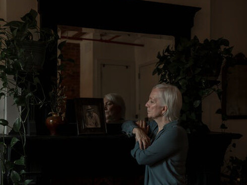 With a tender smile and misty eyes, she lovingly traces the contours of his photograph, lost in memories of a lifetime shared together