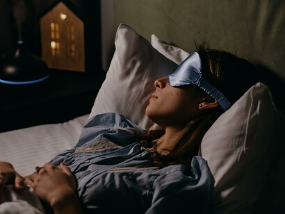 A person sleeping comfortably wearing an eye mask
