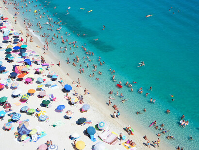 Tourists enjoying the beach and swimming in Tropea, Italy