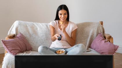 A woman enjoys quality time watching her favorite TV shows