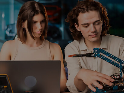 Innovative young man and woman, wearing protective glasses, enthusiastically conduct robotics experiments in a laboratory, showcasing hands-on STEM education