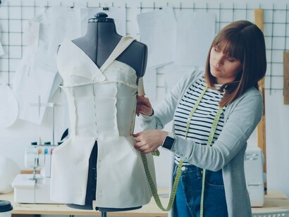 A fashion designer carefully shaping fabric on a dress form, representing the precision and creative problem-solving behind zero waste pattern making