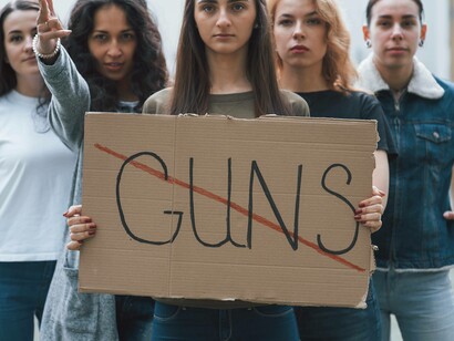 Gruppo di donne con cartellone di protesta: " ... in questa compagine delirante che è la corsa agli armamenti, cerchiamo di rimanere fermi"
