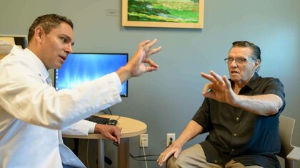 A doctor helping a patient who has Parkinson's disease