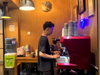 Suradi’s passion for coffee shines through as one of his skilled baristas carefully crafts a perfect cup at Dunia Kopi, where every coffee is made with the utmost care and dedication to quality