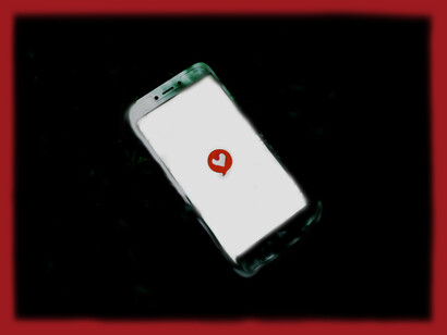 A phone screen showing a heart button, signifying the effect of social media comparisons