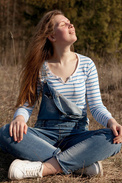 A woman enjoys her time in nature, taking in the beauty around her from a side view