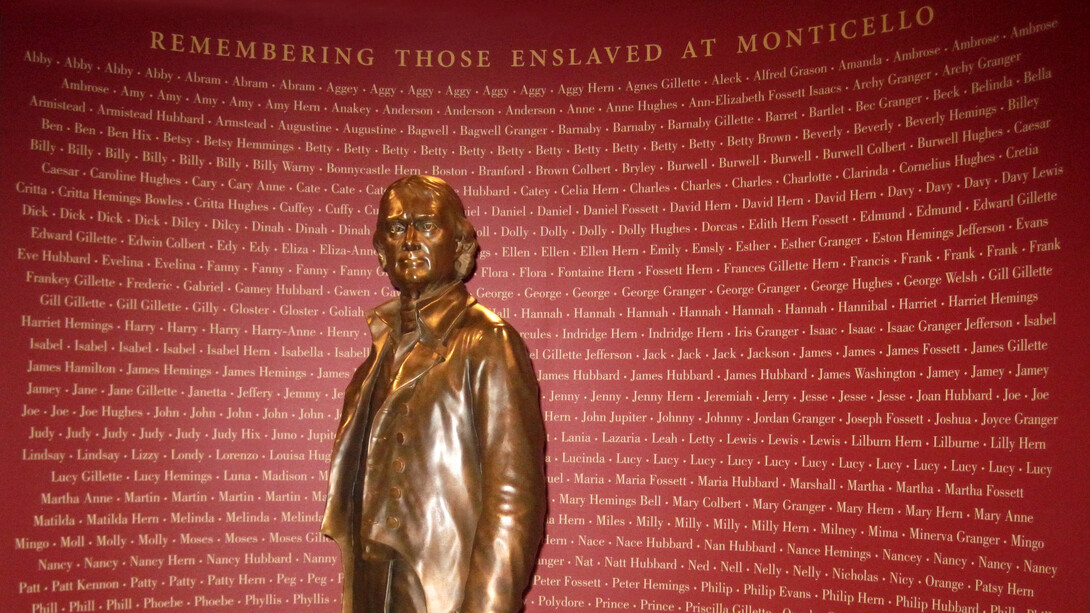 Estatua de Thomas Jefferson frente a un memorial que registra los nombres conocidos de las personas a las que mantuvo como esclavas