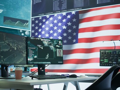 Sala operativa con bandiera americana che scorre su un grande schermo nella torre di controllo