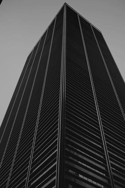 A cityscape of towering skyscrapers in the financial district reflects the concept of business growth and economic ambition