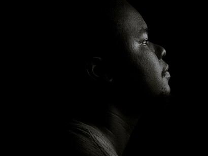 Jeune garçon regardant dans l'obscurité, pensant à sa vie, à l'avenir 