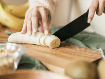 Hands deftly preparing bananas for Bariva, highlighting the meticulous process that blends local ingredients with ancestral wisdom, essential to gatherings and celebrations in the Central province
