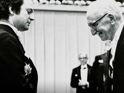 Friedrich Hayek recebendo o prêmio Nobel de Ciências Econômicas, 1974. Hayek é amplamente conhecido por sua teoria sobre a ordem espontânea e o papel do mercado na disseminação de informações. Em sua obra O Caminho da Servidão, publicada em 1944, Hayek argumentou contra as políticas econômicas socialistas e centralizadoras, afirmando que a tentativa de controlar a economia por meio de planejamentos centrais resultaria na perda de liberdades individuais e em uma gestão ineficiente dos recursos. Hayek destacou, assim, a importância de se preservar a liberdade individual e a autonomia do mercado como mecanismos essenciais para a prosperidade e a justiça social