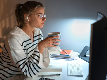 A woman working late at night, immersed in Blockchain technology, decentralized AI, Avalanche blockchain, and AI agents within the Web3 ecosystem
