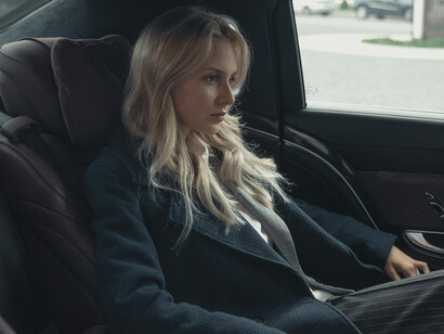 Woman in a business suit sitting in a luxurious car