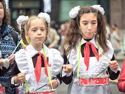 Children in Soviet school uniforms playing drums as Young Pioneers