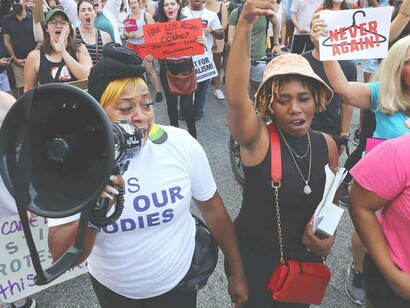 Black protesters against the white supremacy ideology to ban abortion are taking to the streets with a megaphone and people chanting for the cause