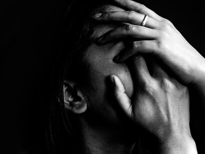 Mujer deprimida se cubre el rostro con las manos