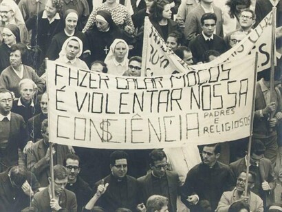 Manifestação de associação de padres e religiosos contra a ditadura militar no Rio de Janeiro, Brasil, cerca de 1970. O Brasil tem uma relação complexa e, em muitos momentos, incômoda com seu passado recente. A ditadura militar, instaurada em 1964, foi um período de tortura, assassinatos, censuras e violações de direitos humanos que deixou cicatrizes profundas no tecido social brasileiro