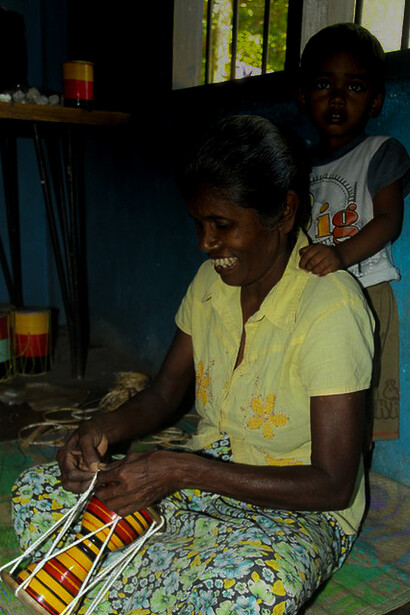 A woman is busy making a traditional drum. There was a time when each drummer was personally responsible for making their drum right from scratch. Village Kuragala in Sri Lanka