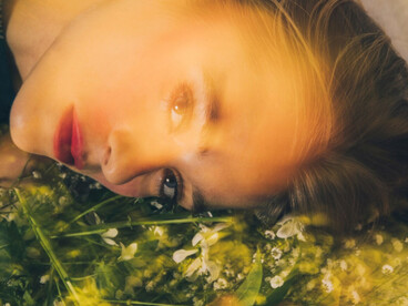 Bathed in light, a model rests close to earth