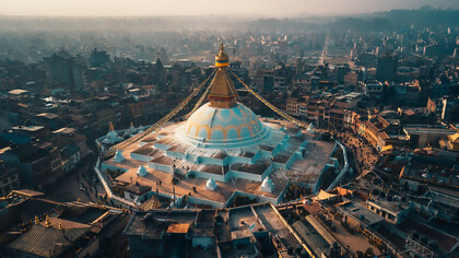 An aerial view of city buildings during the daytime with the Bodhnath Stupa in Kathmandu, Nepal
