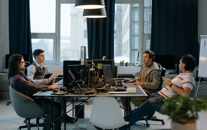 Quatro homens trabalham em frente a computadores num ambiente de escritório. A baixa diversidade nas equipas que desenvolvem inteligência artificial é apontada por especialistas como um dos fatores que contribuem para pontos cegos e vieses nos sistemas. O artigo discute como as escolhas de quem cria a IA influenciam os resultados produzidos pelos algoritmos. A predominância masculina em áreas ligadas à inteligência artificial continua a ser um desafio para a diversidade de perspectivas no setor