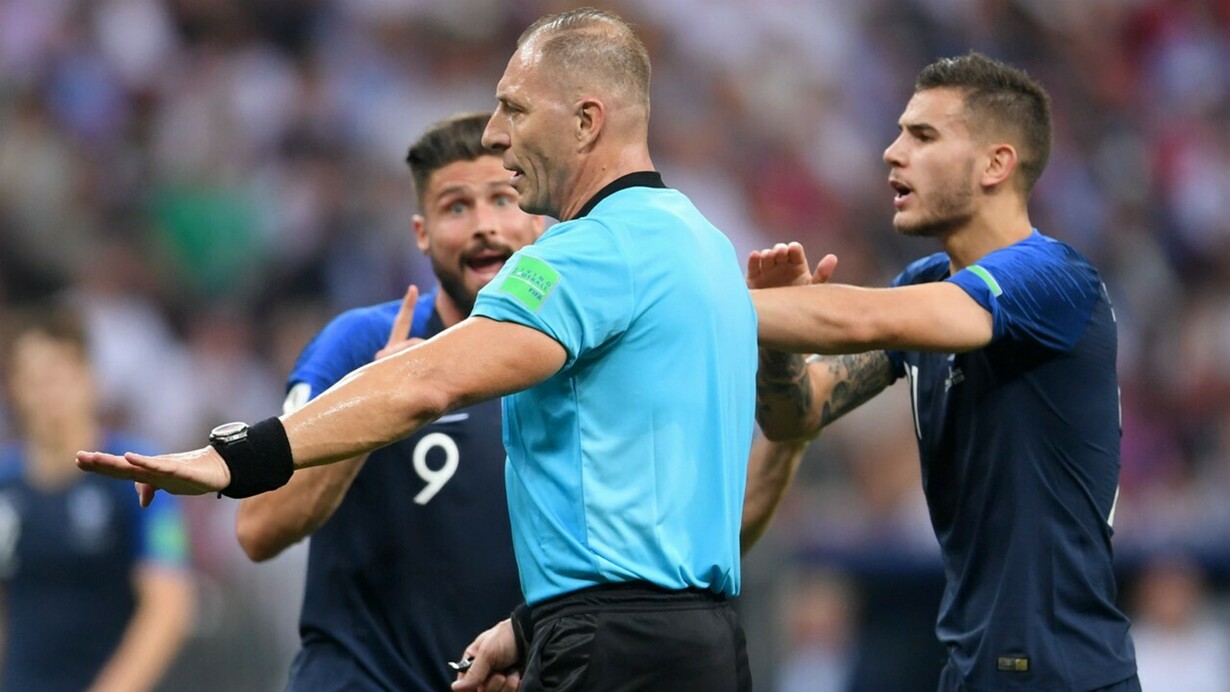Néstor Pitana, el árbitro de la final del Mundial de Rusia, entre dos jugadores de la selección francesa