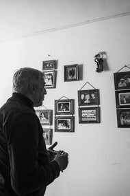 Man reflecting on family memories in a black-and-white photograph