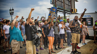 Raised fists of the people protesting together symbolize resistance and the fight against power