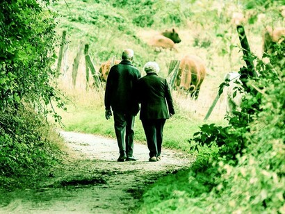 Coppia di anziani che cammina su un sentiero di campagna