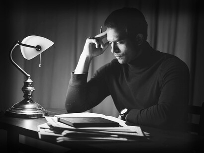 Homem contemplativo lendo livro em seu escritório