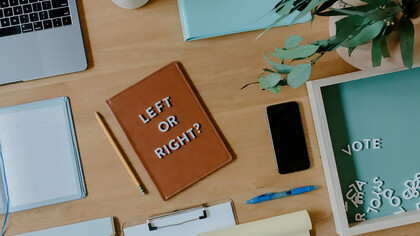 On the desk, Left or right? written on a notebook emphasizes the importance of voting
