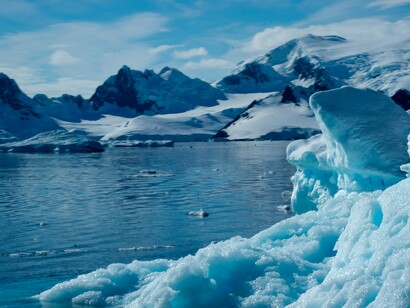 An iceberg surrounded by snow-covered peaks, reflecting Antarctica’s immense natural wealth and geopolitical significance