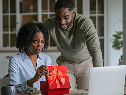 Woman showing disappointment while receiving a gift from a man, highlighting emotional pressure and control in the relationship