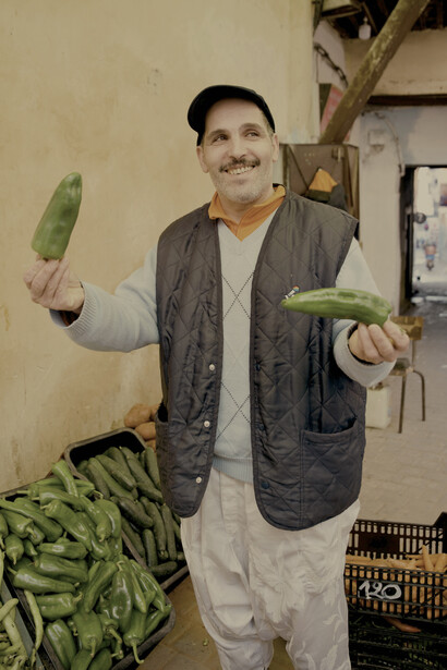 Vendedor ambulante ofreciendo su mercancía con una sonrisa. Viscarra representa con humor y compasión distintos aspectos de la vida