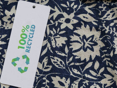 This close-up of a clothing tag with a recycling icon represents the essential concept of recycling in fashion