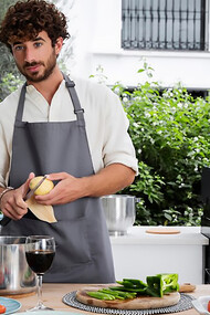 A male vlogger, live-streaming his cooking, exemplifies the impact of social media on culinary trends as a food influencer