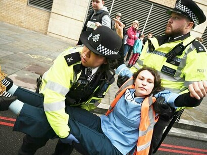 Ativista é detida em manifestação do grupo ativista "Just Stop Oil" em Londres, 2022. Pesquisas sugerem que, embora haja um apoio generalizado à necessidade de enfrentar a mudança climática, a maioria das pessoas se opõe às táticas do grupo