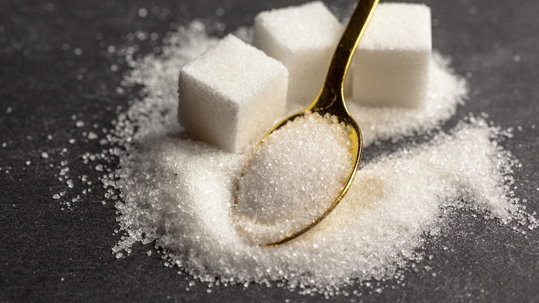 Sugar cubes stacked on a table represent the growing debate over sugar consumption and taxation